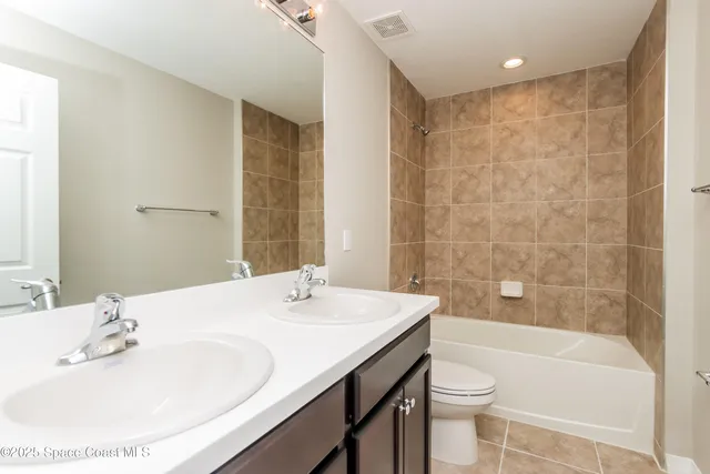 a bathroom with a bathtub shower sink vanity and toilet