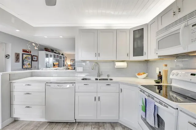 a kitchen with cabinets appliances a sink and a counter top space