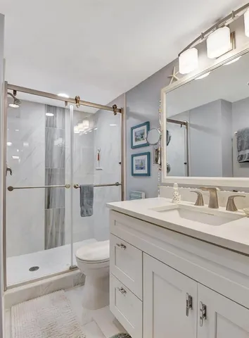 a bathroom with a granite countertop sink toilet and shower