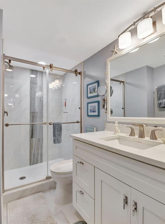 2615 Northeast 3rd Street, Unit 301 Boynton Beach, FL 33435 - Photo 24 of 67 a bathroom with a double vanity sink toilet and shower