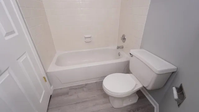 a white toilet sitting next to a bath tub