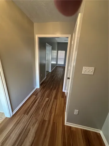 a view of a hallway with wooden floor and staircase