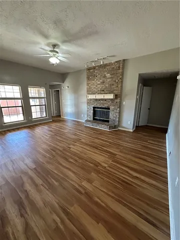 wooden floor fireplace and windows in an empty room