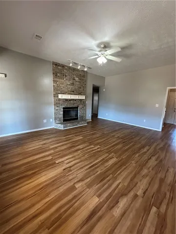 wooden floor fireplace and windows in an empty room