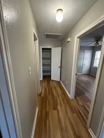 a view of a hallway with wooden floor and staircase