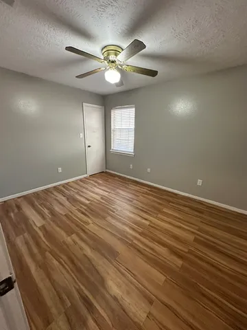 a view of an empty room with a chandelier fan