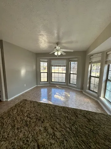 a view of an empty room with window and fireplace