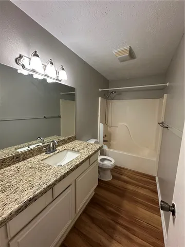 a bathroom with a granite countertop sink toilet and shower
