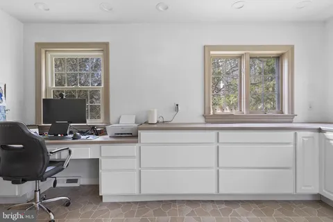 a spacious bedroom with a bed a couch and a flat tv screen on the dresser