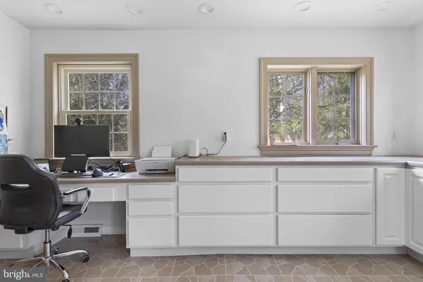a spacious bedroom with a bed a couch and a flat tv screen on the dresser
