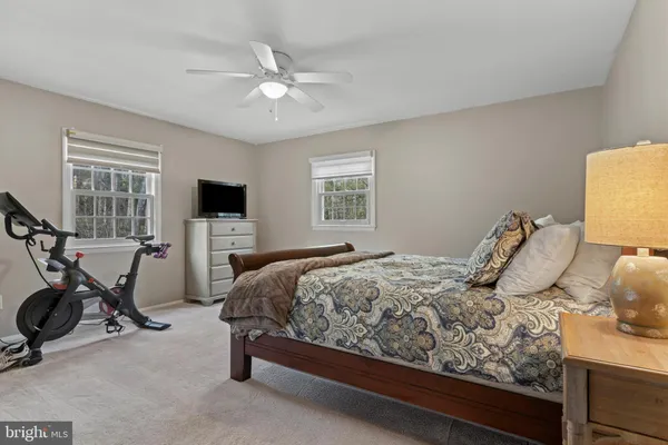 a bedroom with a baby bed a couch and a window