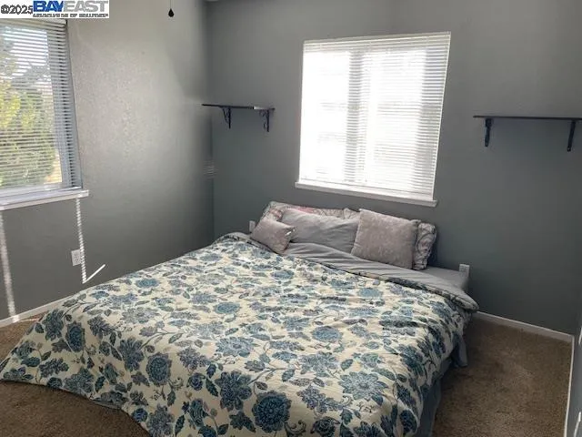 a large bed sitting in a bedroom next to a window