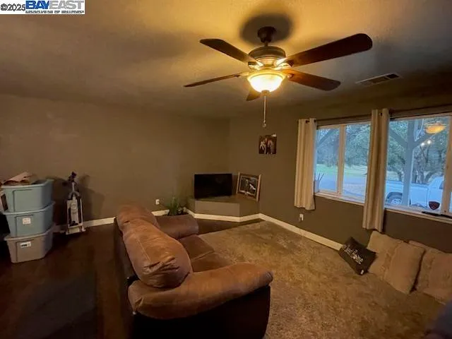 a living room with furniture and a ceiling fan