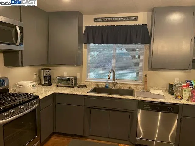 a kitchen with a sink a stove and cabinets