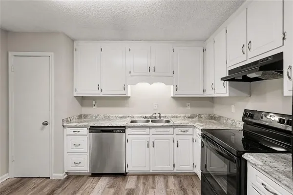a kitchen with white cabinets and appliances