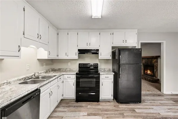 a kitchen with a refrigerator sink and cabinets