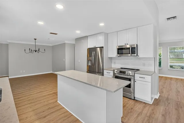 a kitchen with kitchen island a stove a sink and a refrigerator