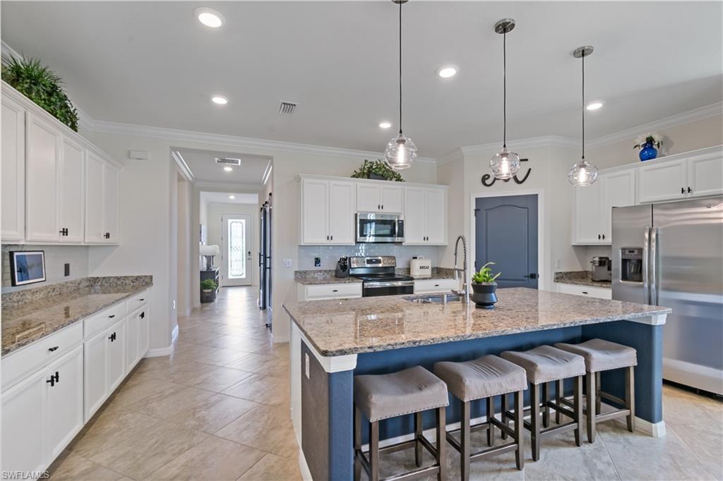 a kitchen with granite countertop a table and chairs in it
