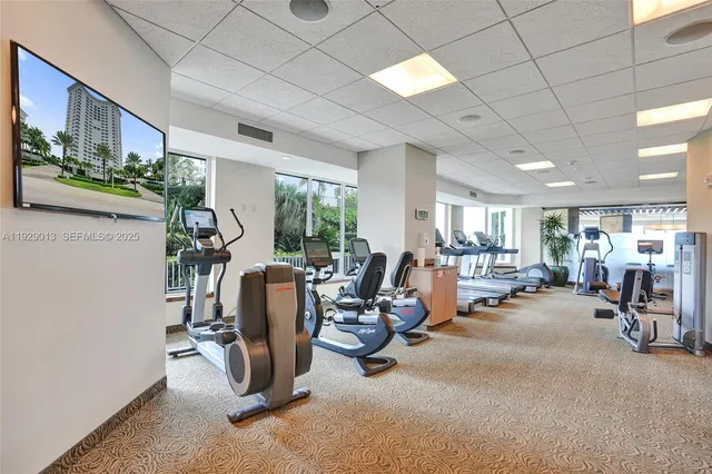 a room with lots of white furniture wooden floor and a large window