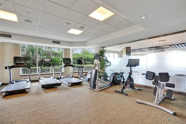 a living room with furniture large window and wooden floor