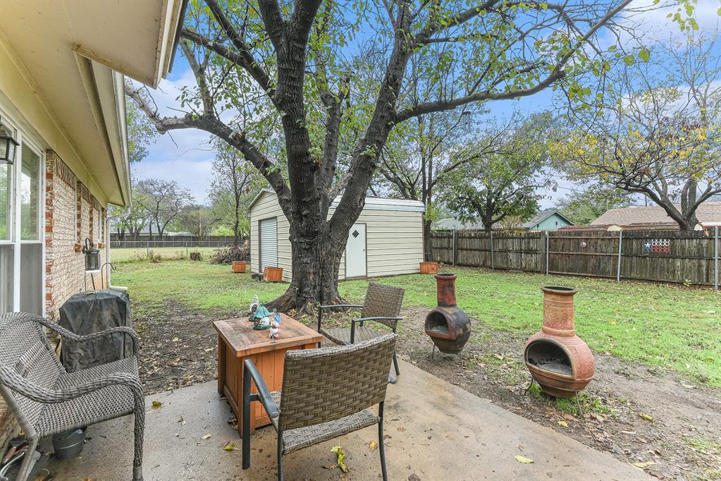 6608 Swanee Court Watauga, TX 76148 - Photo 28 of 30 a view of backyard with table and chairs and large trees