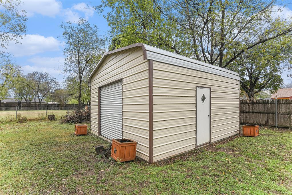 6608 Swanee Court Watauga, TX 76148 - Photo 30 of 30 a view of a backyard with a barbeque grill and wooden fence