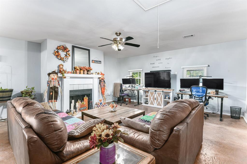 6608 Swanee Court Watauga, TX 76148 - Photo 4 of 30 a living room with furniture a flat screen tv and a fireplace