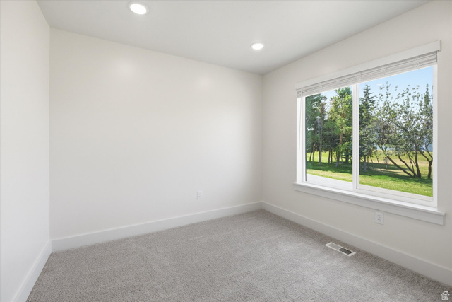 730 West 500 North Smithfield, UT 84335 - Photo 17 of 46 Bright room featuring a large window, recessed lighting, neutral carpeting, white baseboards, and a fresh white paint palette