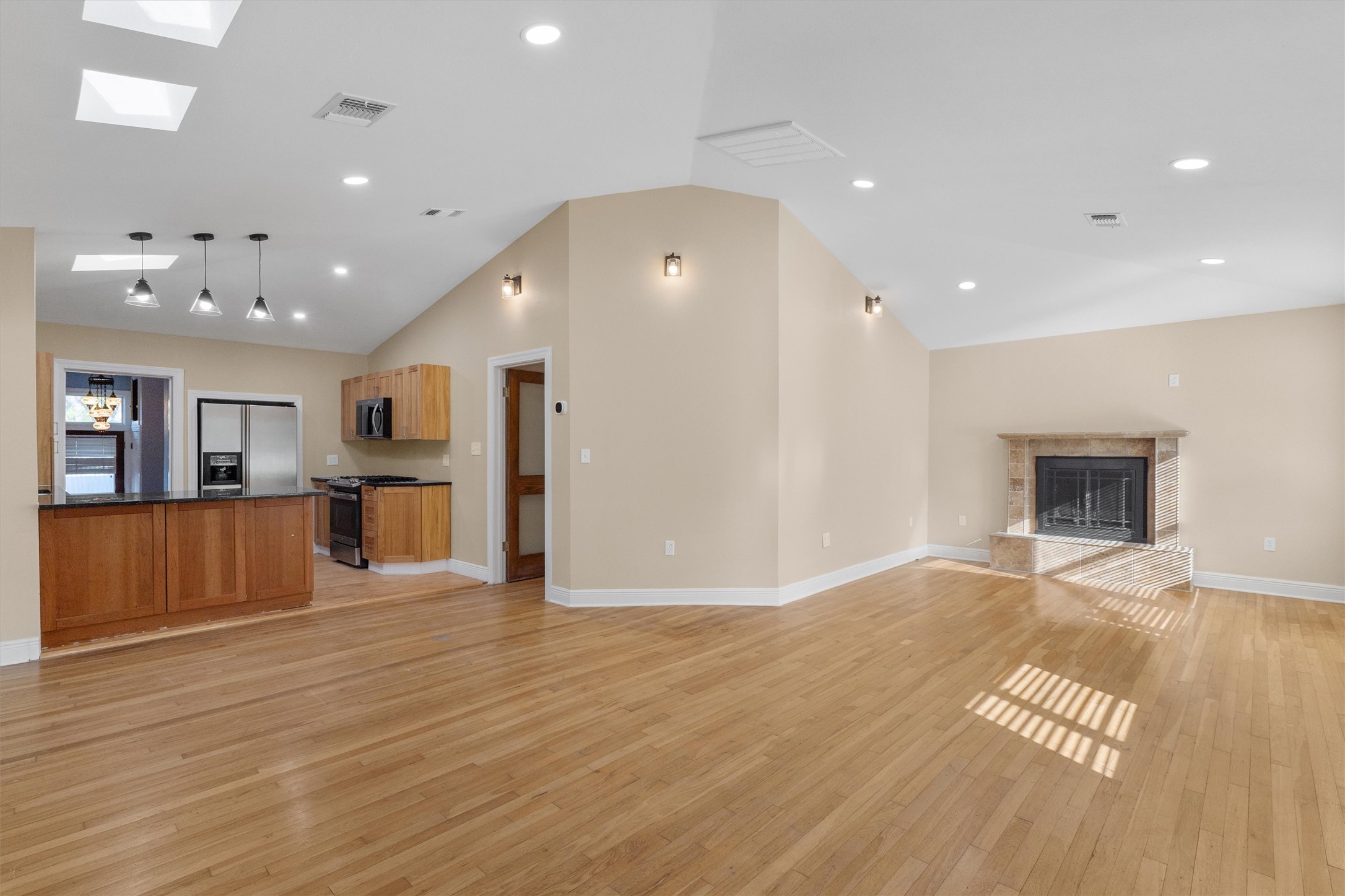 400 East Monroe Street Austin, TX 78704 - Photo 7 of 39 a view of an empty room with wooden floor and a kitchen