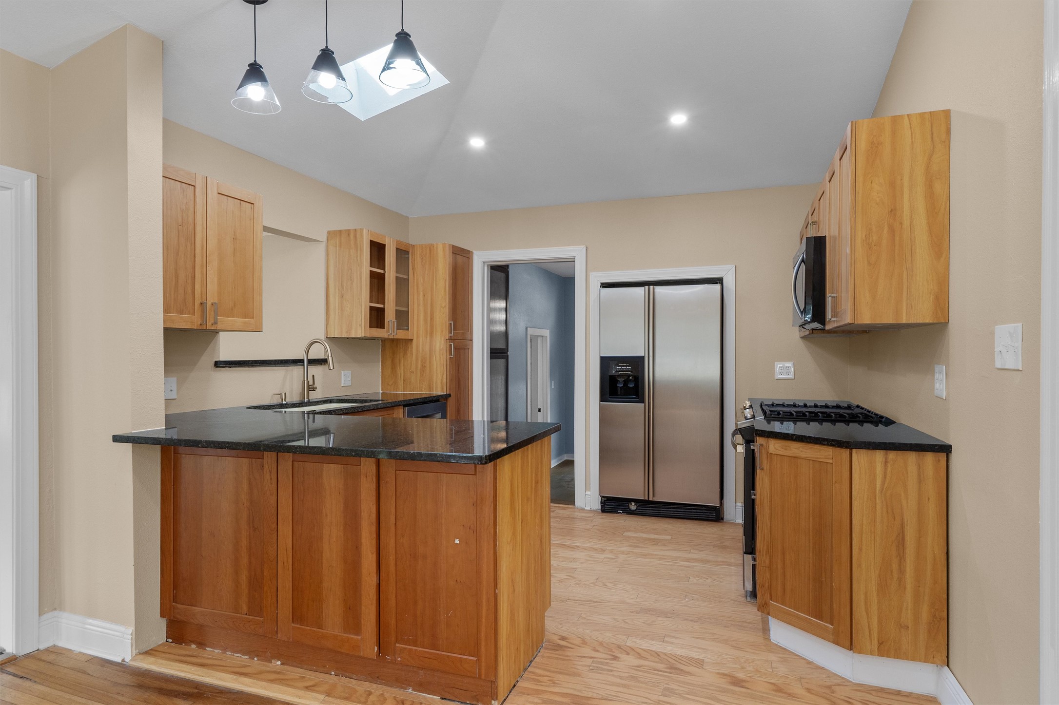 400 East Monroe Street Austin, TX 78704 - Photo 10 of 39 a kitchen with stainless steel appliances granite countertop a refrigerator a sink dishwasher and wooden cabinets with wooden floor