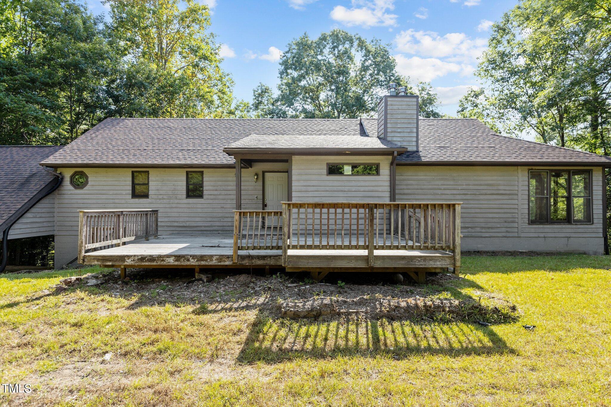 5900 Ebenezer Church Road Raleigh, NC 27612 - Photo 21 of 71 a view of a house with a wooden deck and a yard