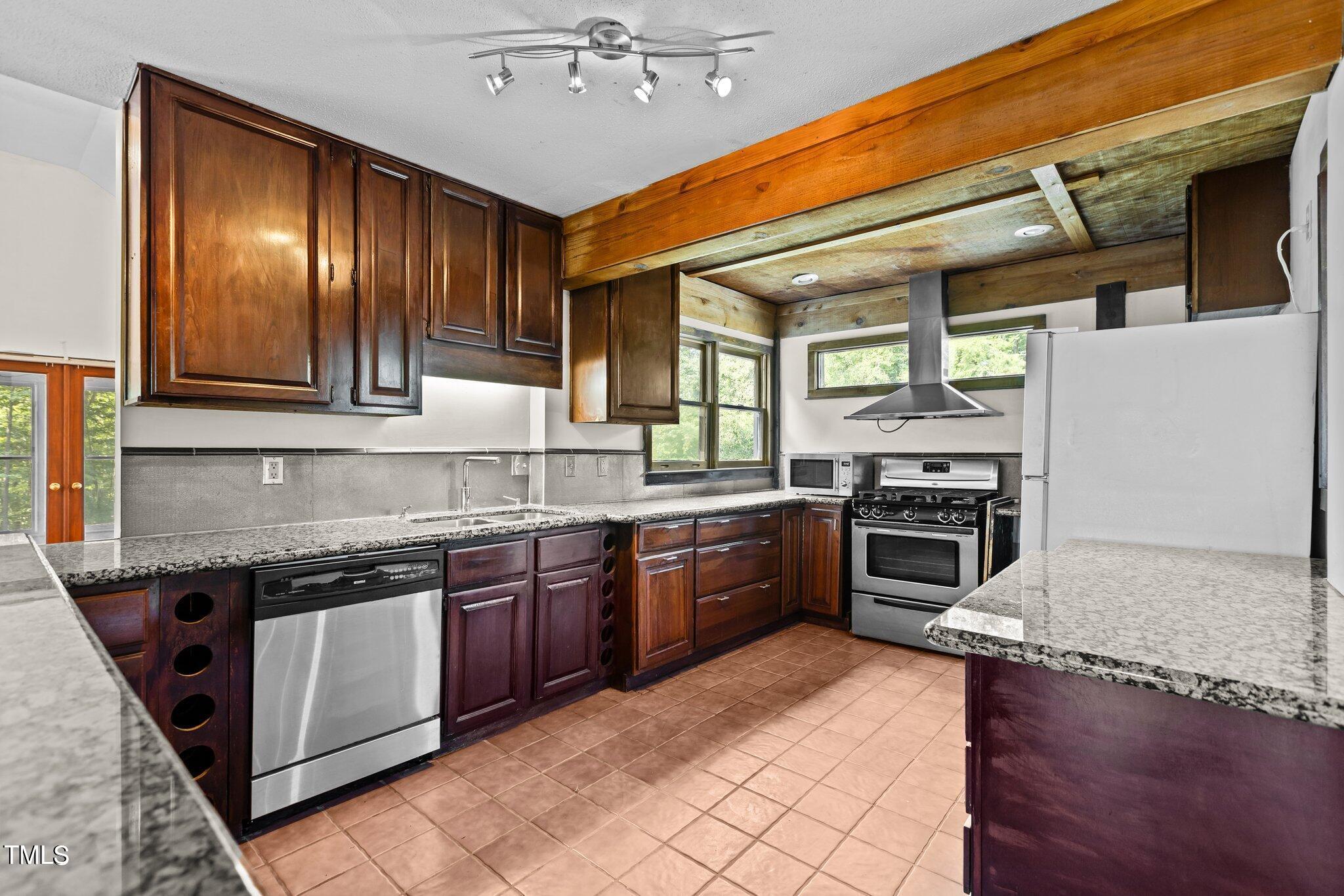 5900 Ebenezer Church Road Raleigh, NC 27612 - Photo 29 of 71 a kitchen with stainless steel appliances granite countertop a stove a sink and a microwave
