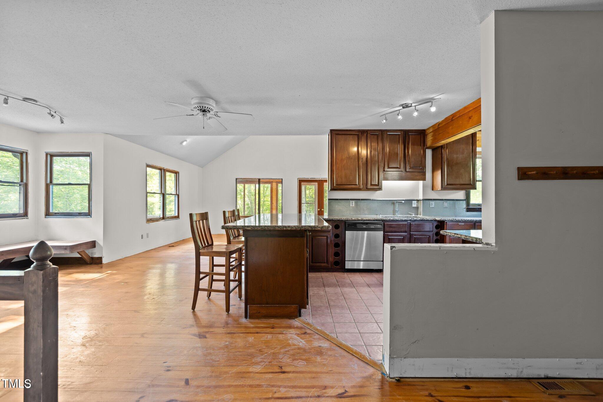 5900 Ebenezer Church Road Raleigh, NC 27612 - Photo 34 of 71 a kitchen with kitchen island granite countertop wooden floors and wooden cabinets