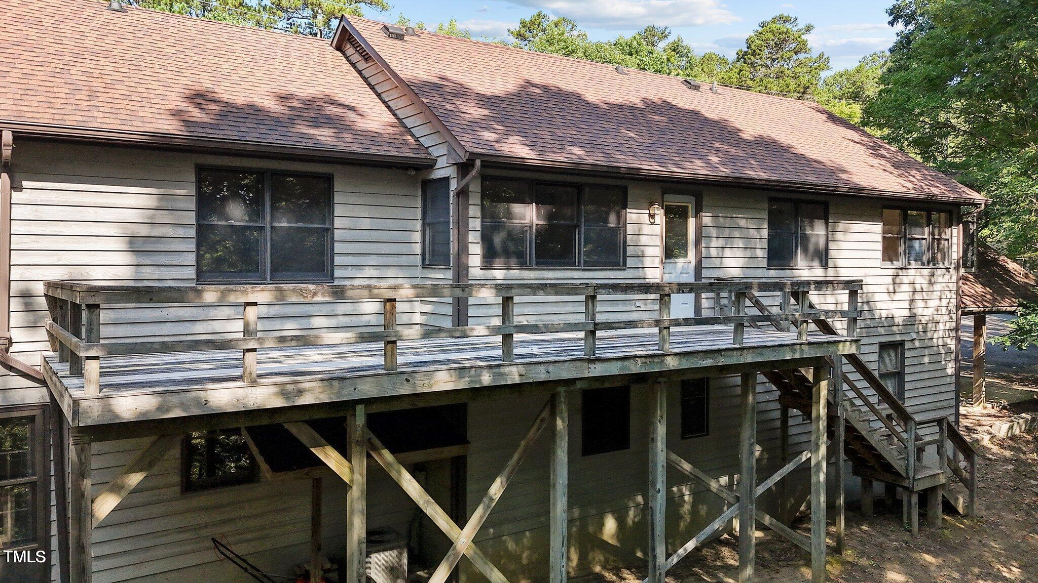 5900 Ebenezer Church Road Raleigh, NC 27612 - Photo 51 of 71 a backyard of a house with wooden deck table and chairs