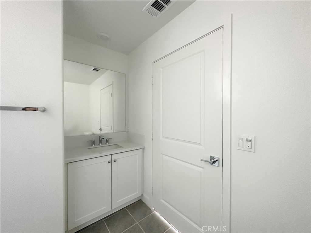 322 Tank Irvine, CA 92618 - Photo 6 of 43 a bathroom with a granite countertop sink a mirror and a shower