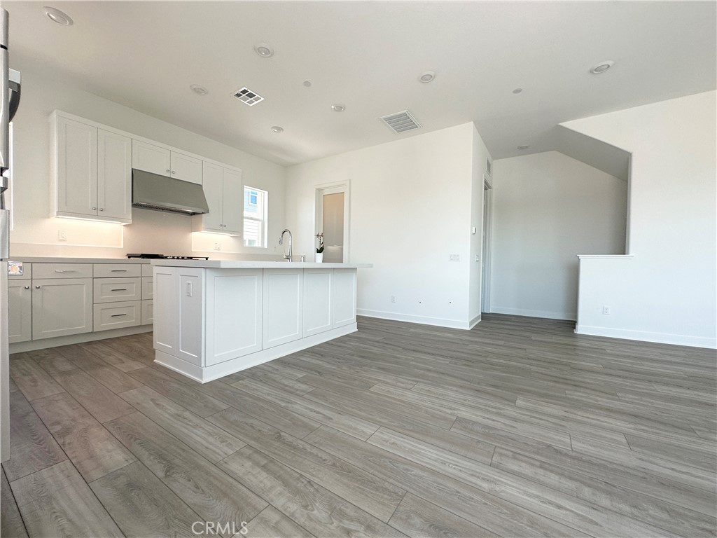 322 Tank Irvine, CA 92618 - Photo 8 of 43 a large kitchen with wooden floors and white cabinets