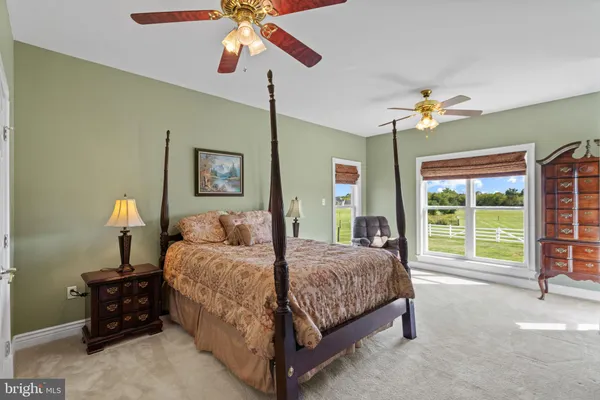 a bedroom with a bed chandelier and a window