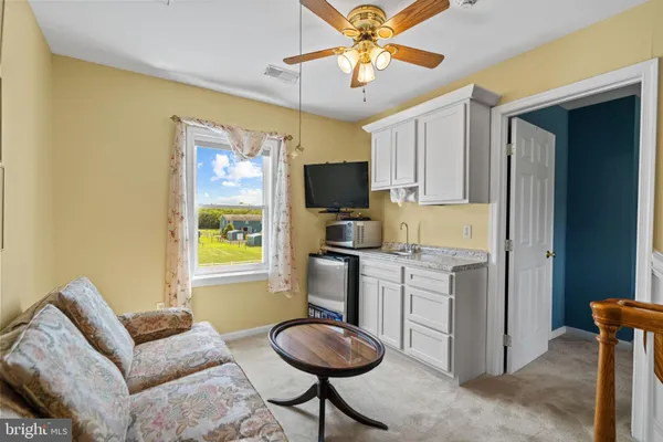 a kitchen with stainless steel appliances granite countertop a stove a refrigerator and a couch