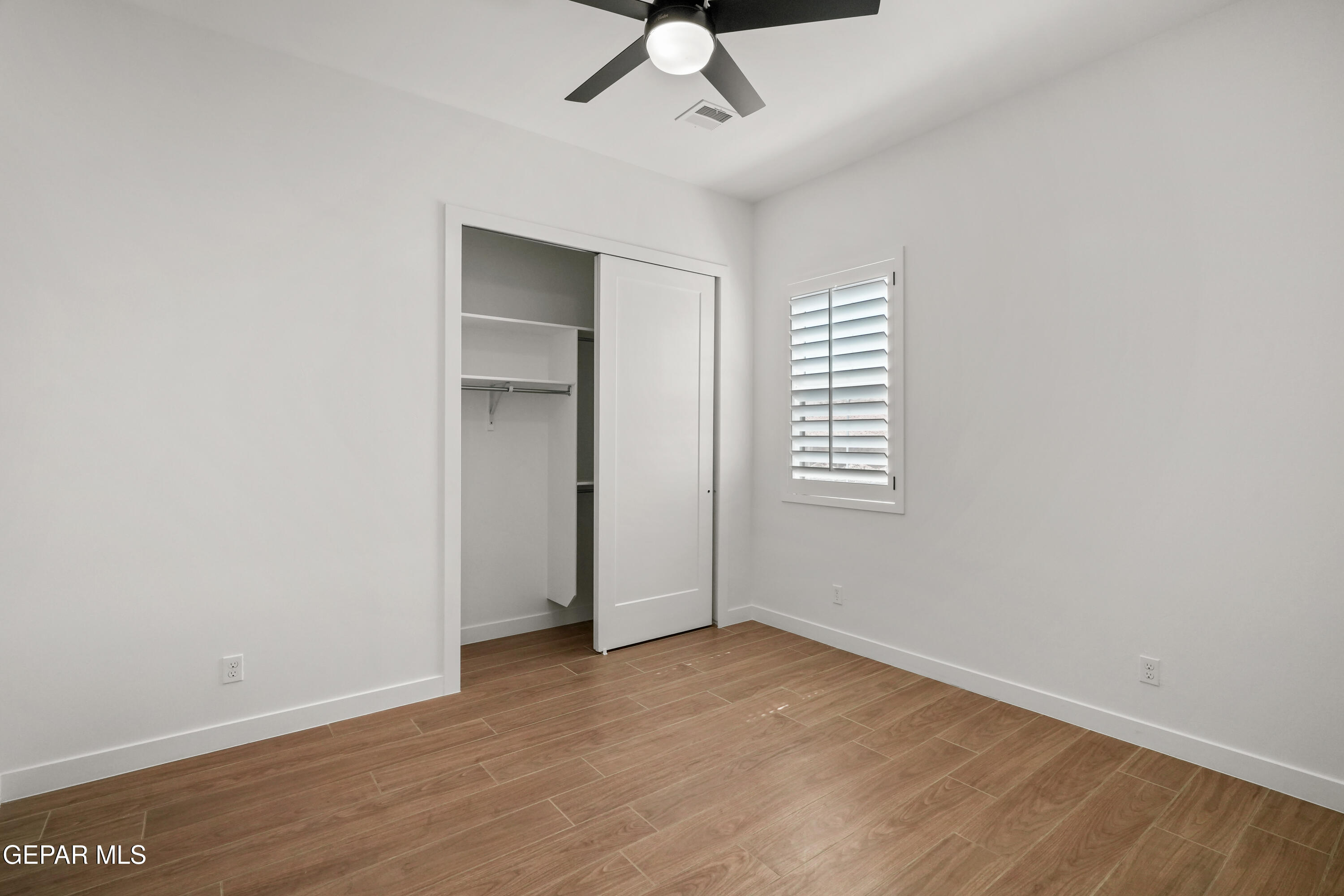 15225 Expectation El Paso, TX 79938 - Photo 2 of 38 a view of an empty room with wooden floor and a ceiling fan