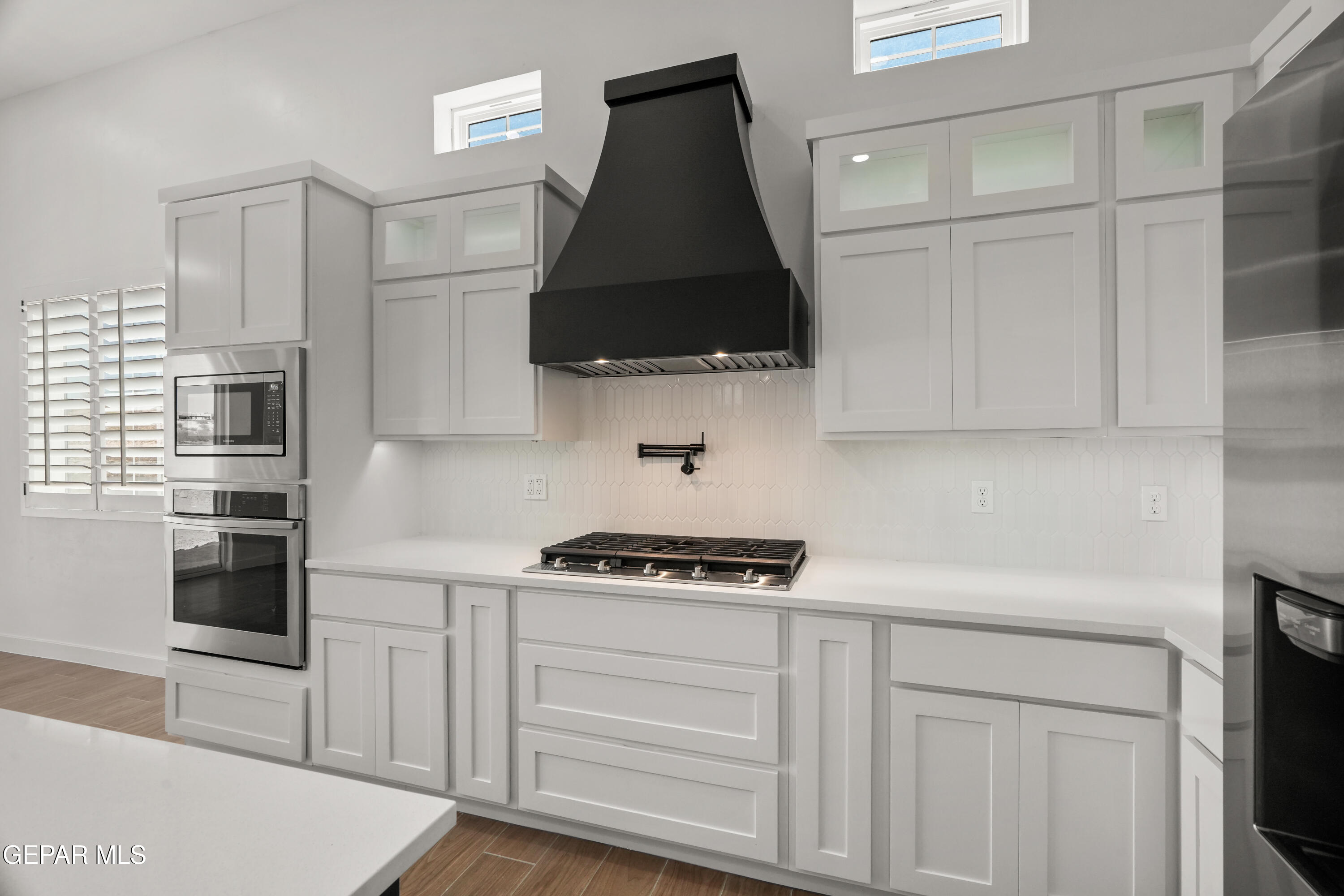 15225 Expectation El Paso, TX 79938 - Photo 23 of 38 a kitchen with white cabinets and black appliances