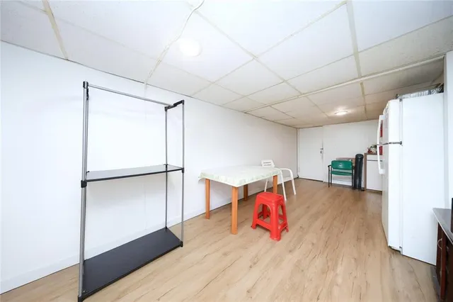 a living room with stainless steel appliances furniture and a refrigerator