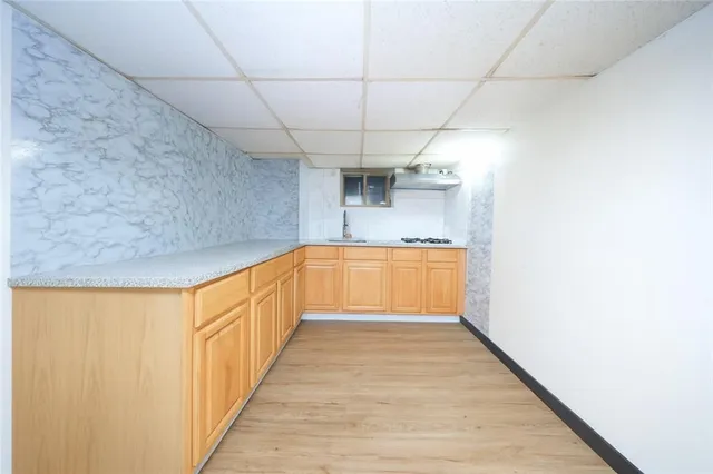 a view of a kitchen with a sink and wooden floor