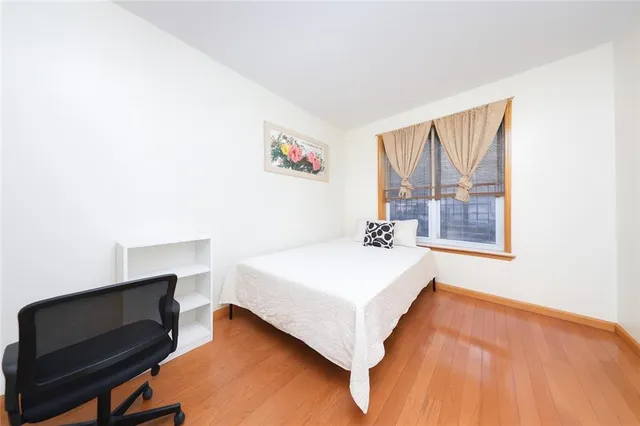a view of bedroom with natural light and wooden floor