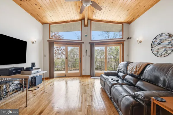 a living room with furniture a flat screen tv and a floor to ceiling window