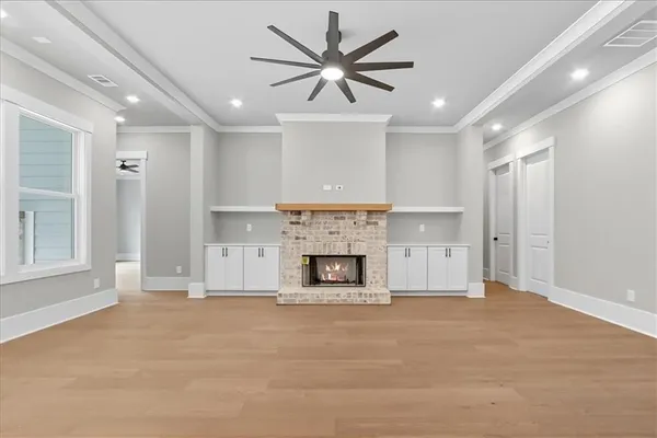 a view of an empty room with kitchen appliances and a ceiling fan