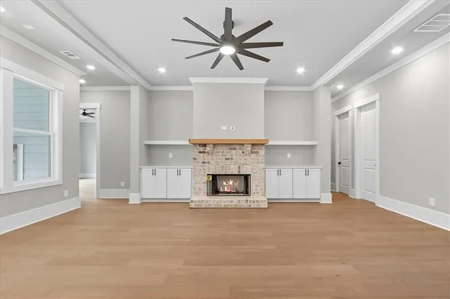 a view of an empty room with kitchen appliances and a ceiling fan