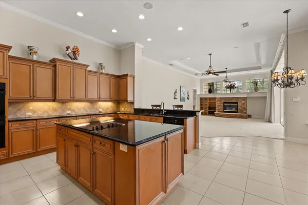 a kitchen with stainless steel appliances granite countertop a stove top oven a sink dishwasher and a refrigerator with wooden cabinets