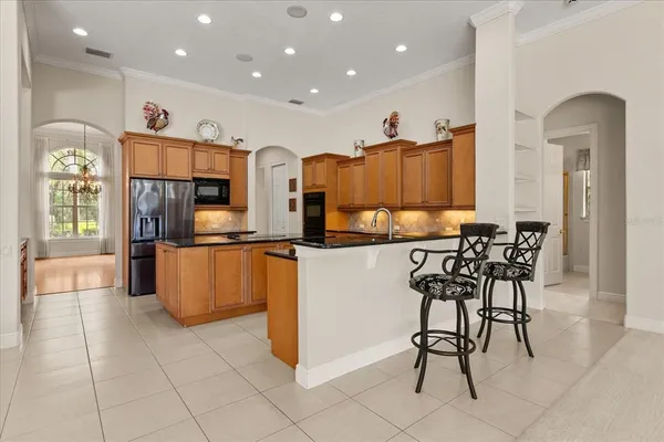 a kitchen with stainless steel appliances kitchen island granite countertop a refrigerator and microwave