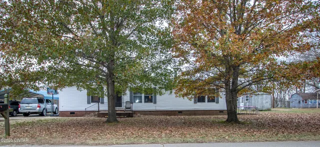 a tree in front of a white house