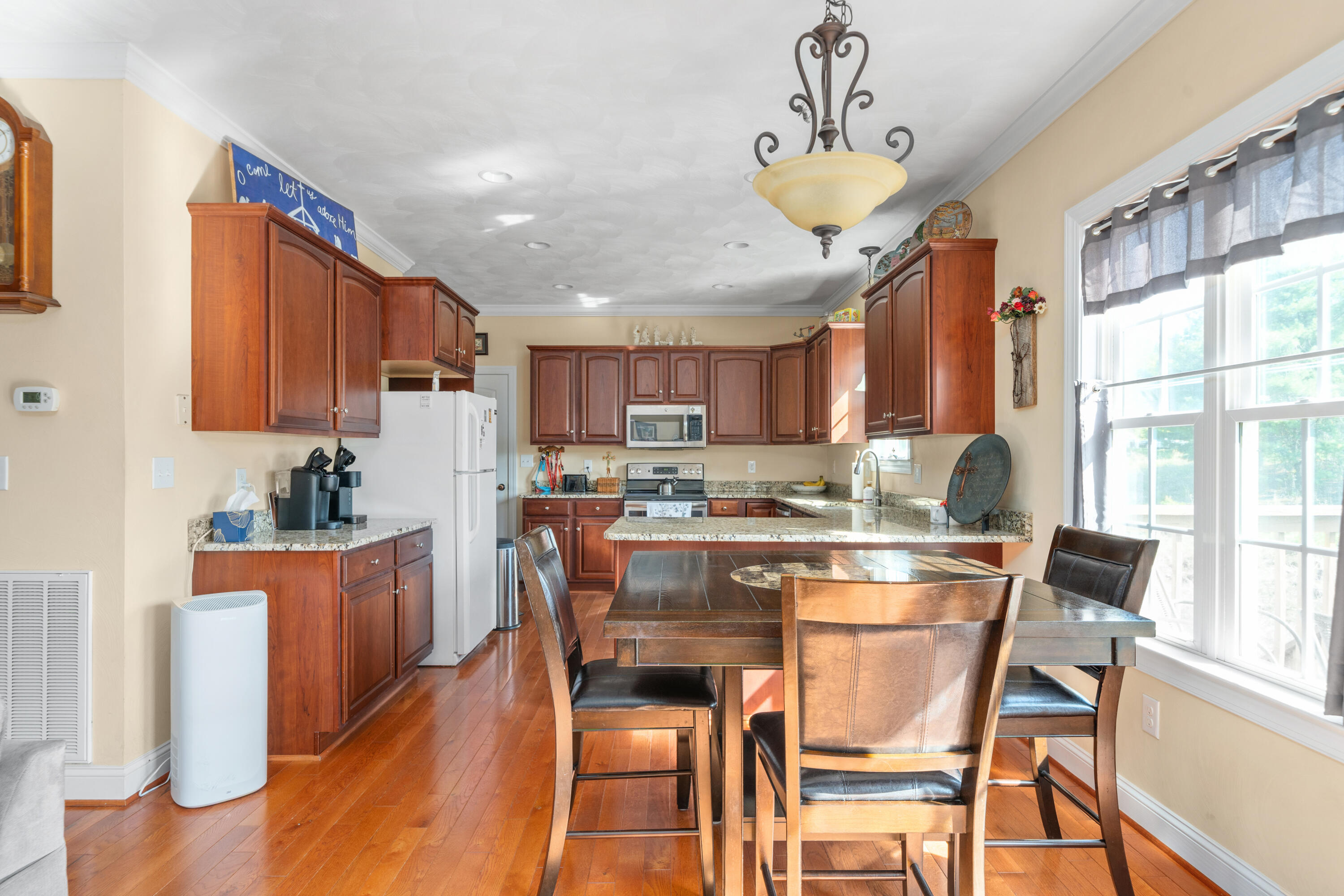 250 Thornblade Way Blue Ridge, VA 24064 - Photo 12 of 31 a kitchen with stainless steel appliances granite countertop a stove top oven a refrigerator a sink a dining table and chairs with wooden floor